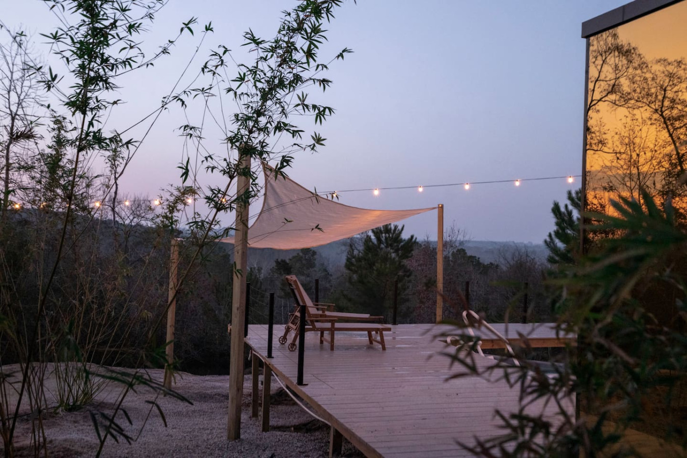 Dusk view of Mirror House deck with shade sail and lounge chairs